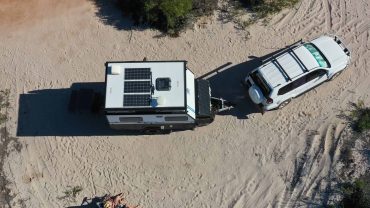 RV with solar panels parked in remote outback area.