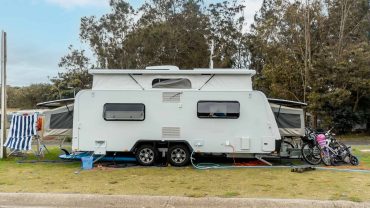 Camping caravan with bicycles and outdoor gear for road trip adventures.