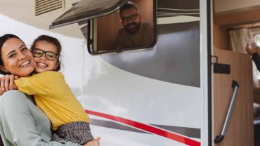 Family enjoying outdoor time near a caravan, capturing happy moments during travel.