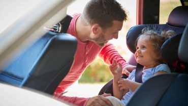 Family road trip, father and daughter in car seat, happy travel moment.