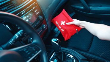 First aid kit in vehicle interior for emergencies, placed on passenger seat.