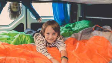 Camping with kids inside a campervan, enjoying a fun outdoor adventure.