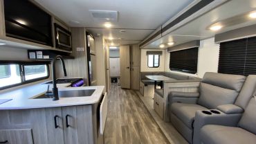 Modern RV interior with kitchen and lounge area for travel comfort.
