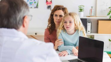 Woman and child consulting with a doctor about the Big Lap Bible.