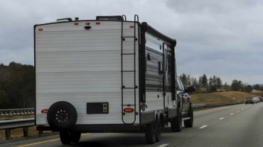 Travel trailer hitched to vehicle on Australian highway.