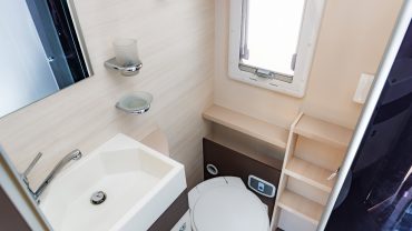 RV bathroom with sink and toilet, compact and modern design.